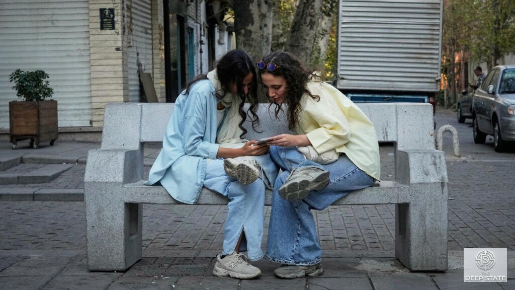 Two women share a phone in Tehran as citizens pay exorbitant prices for internet access.